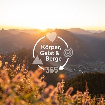 Logo Körper, Geist & Berge vor Sonnenaufgang über dem Berg mit Blick vom Feuerkogel
